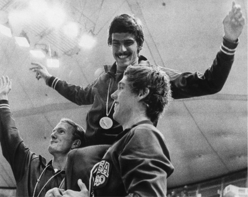 American swimmers Tom Bruce (left) and Mike Stamm (right) carry teammate Mark Spitz on their shoulders during the medal ceremony for their victory in the men's 4x100-meter medley relay race